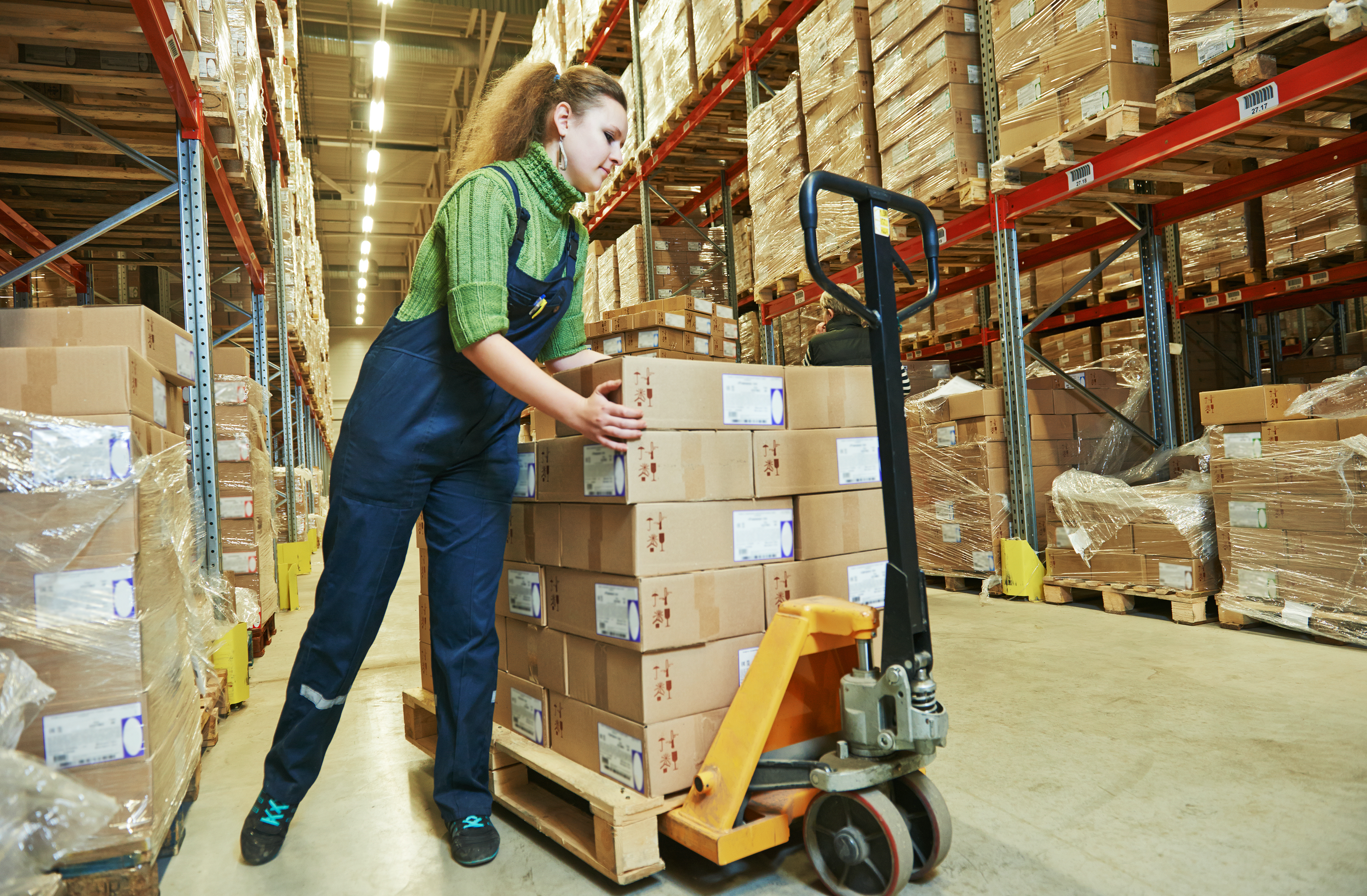 Woman pushing boxes in warehouse